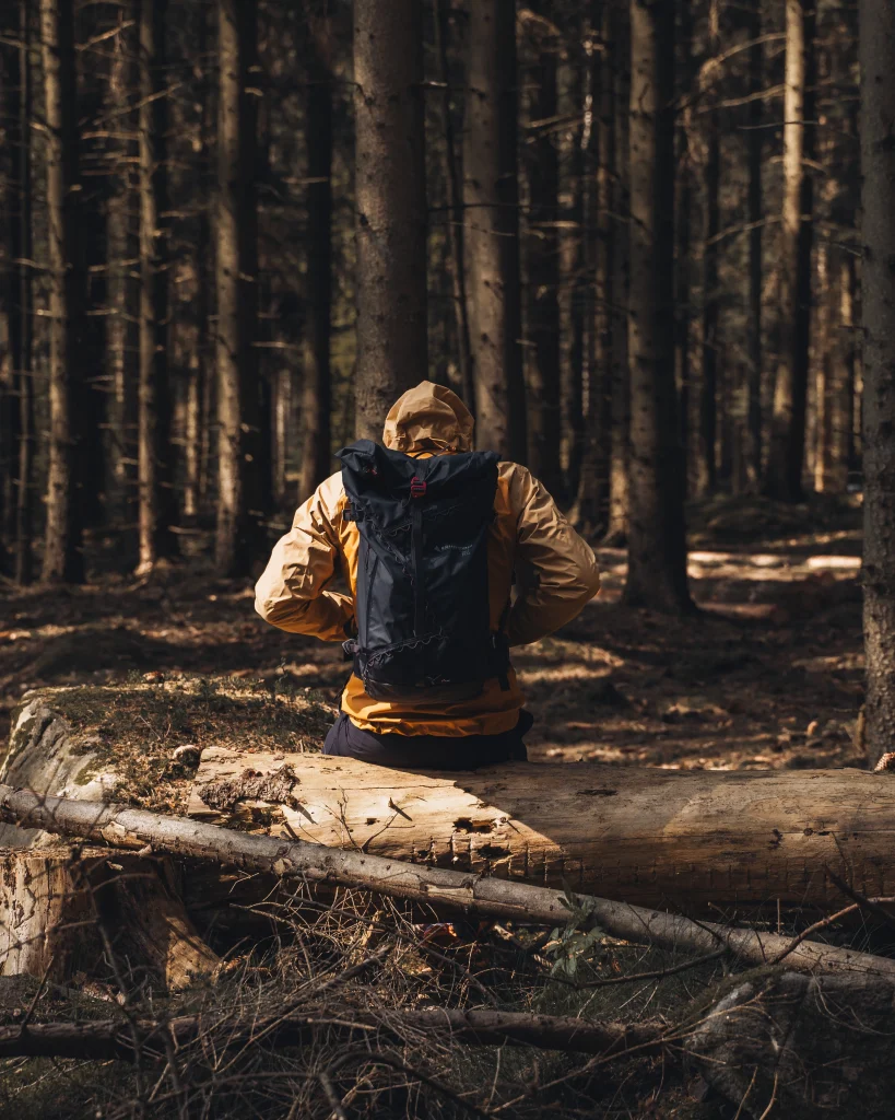 Ny produktionsdag för Naturkompaniet 3 Bild på kille som sitter i skogen med kläder från naturkompaniet